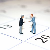 カレンダーと話し合う二人のビジネスマン